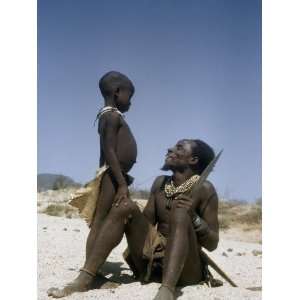  A Seated Kuvale Herdsman Beams at His Young Son Who Stands 