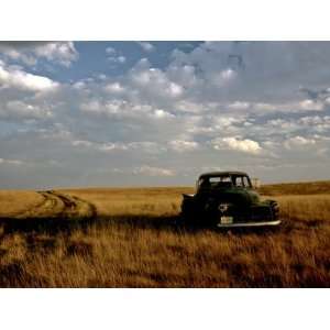  A Landscape of an Old Farm Truck in a Field at Sunset 