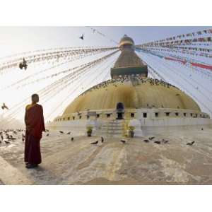 Young Buddhist Monk Turns to Look at the Dome of Boudha Tibetan Stupa 